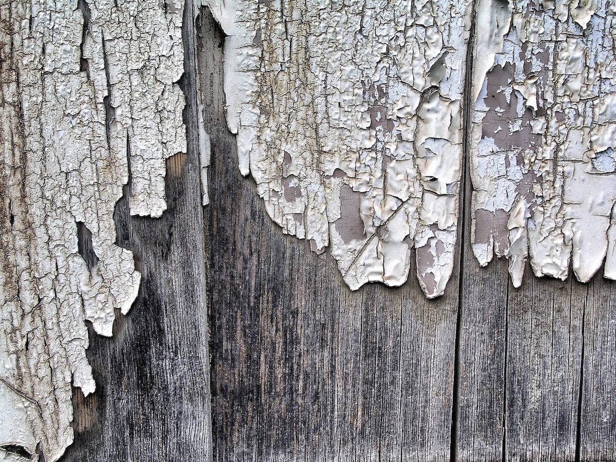 Paint peeling off of a wood fence at an older Missouri home